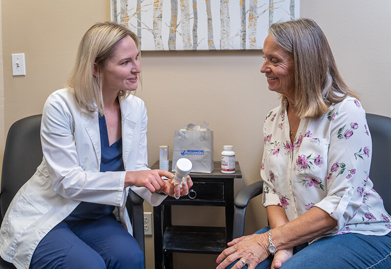 A pharmacist hands a patient his custom-made medications