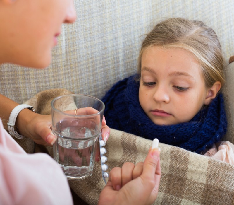 A mother giving her daughter a compounded prescription for the child's pediatric healthcare needs.